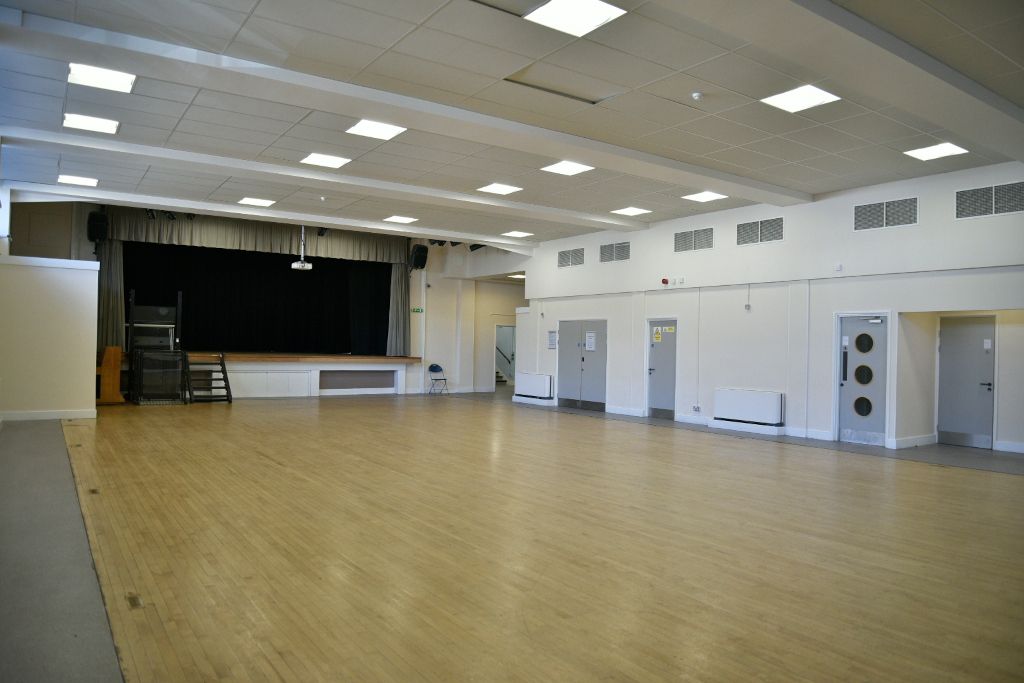 The Ripple Centre main hall with a stage at one end, store rooms and toilets along the side.